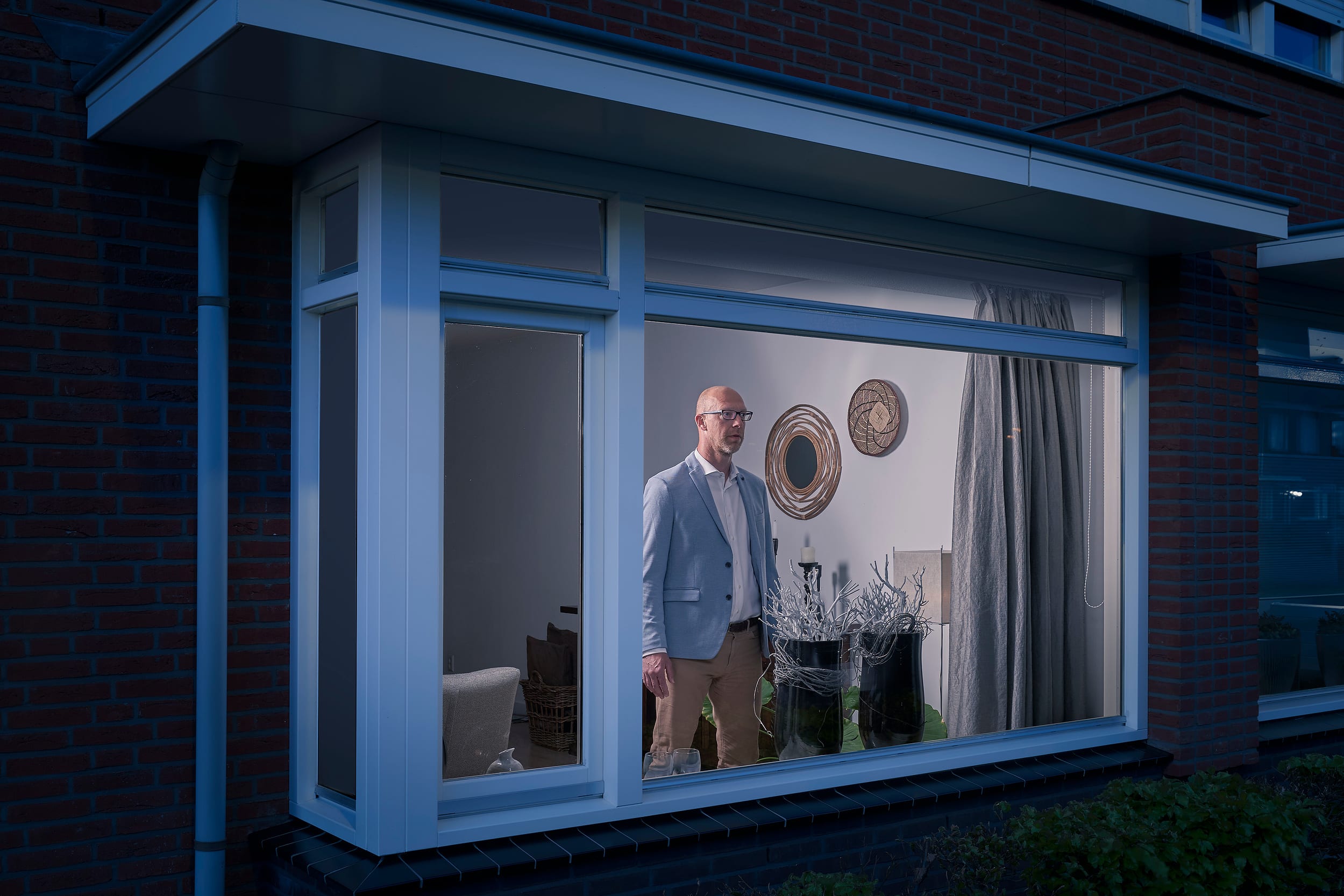 Marcel standing behind the window of his home during lockdown