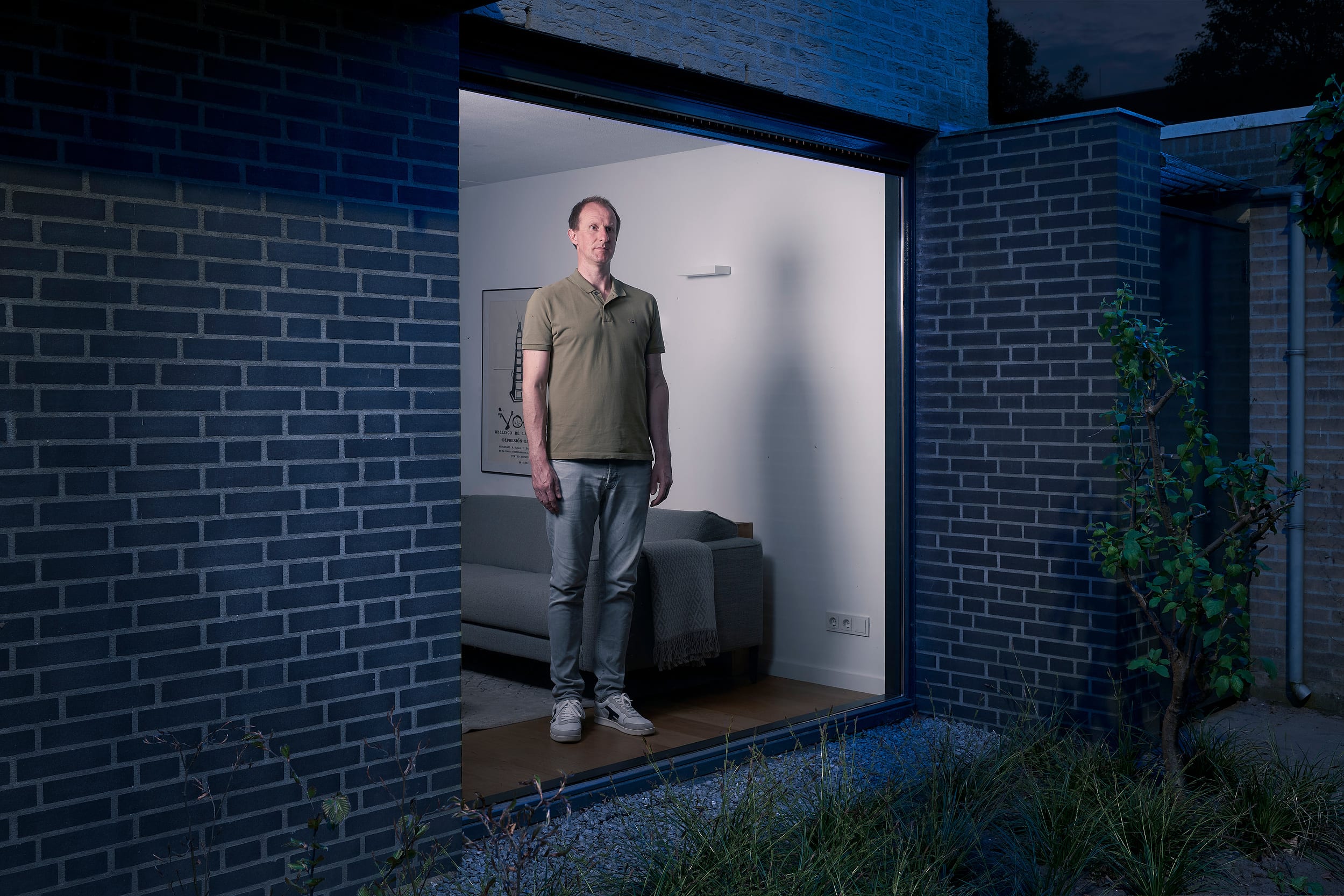 Job standing behind the window of his home during lockdown