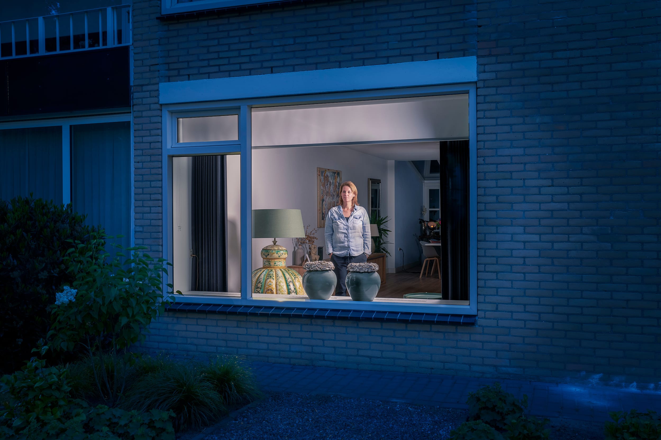 Betty standing behind the window of her home during lockdown