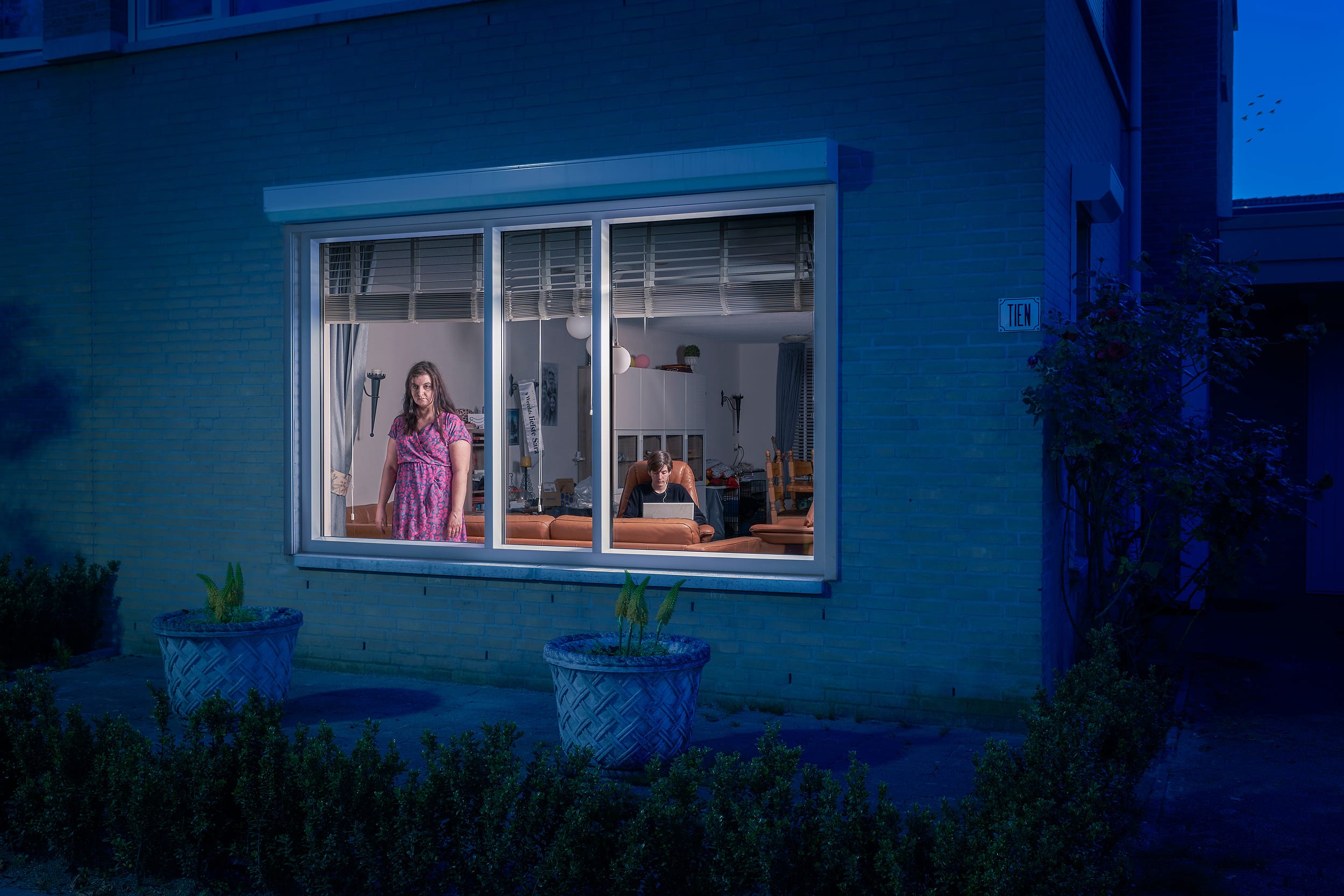 Ingrid standing behind the window of her home during lockdown