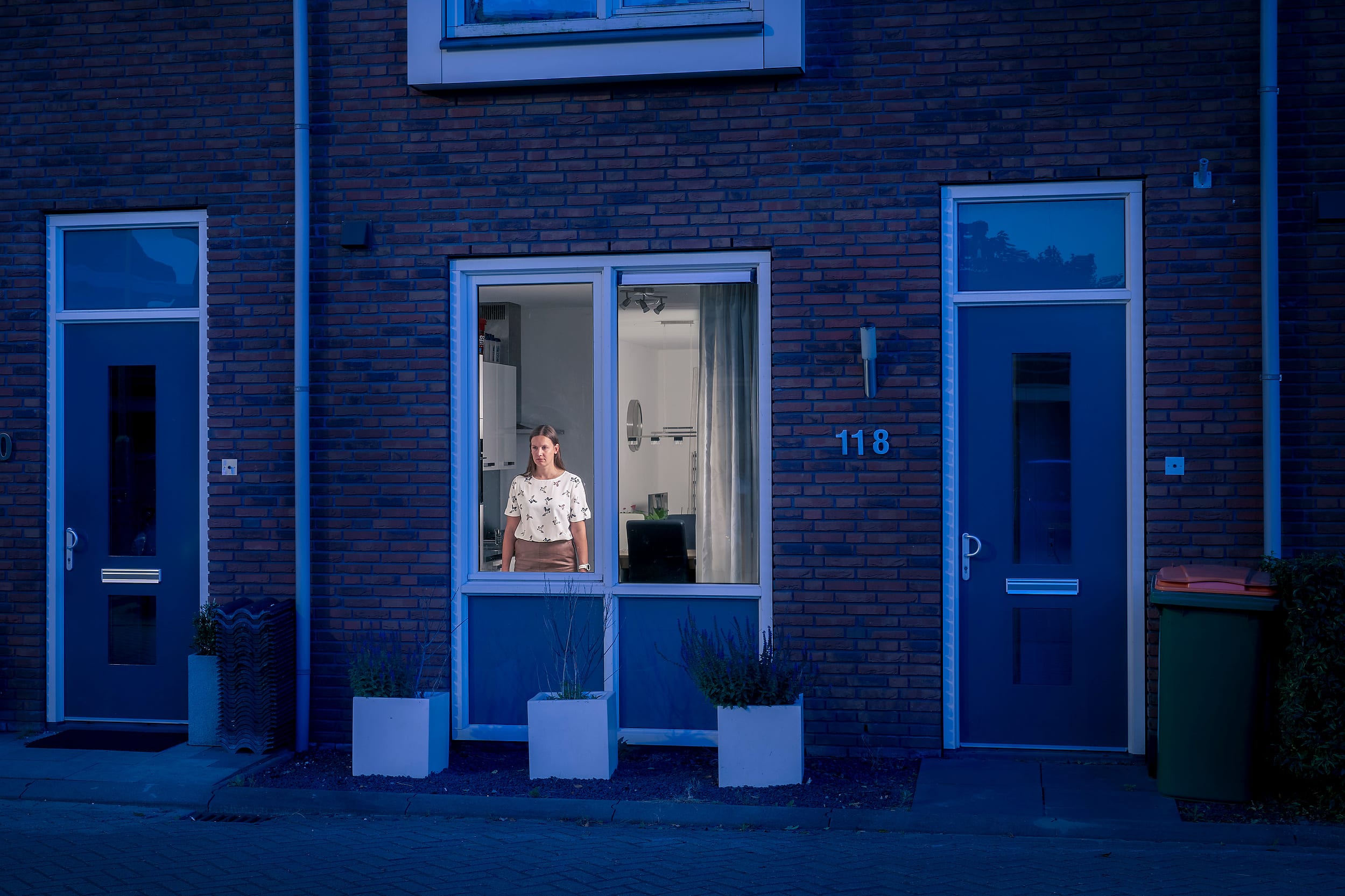 Marlou standing behind the window of her home during lockdown